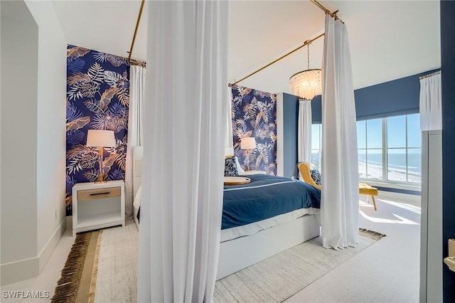 bedroom featuring a chandelier, a water view, and hardwood / wood-style flooring