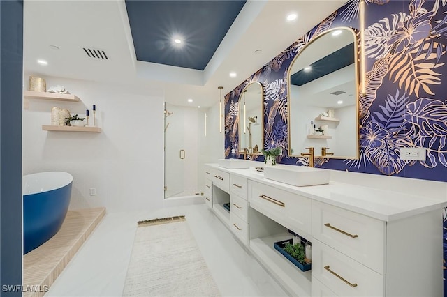 bathroom with a raised ceiling, vanity, and independent shower and bath