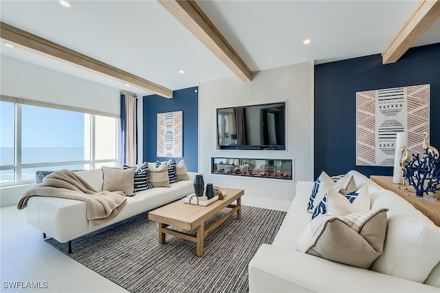 living room featuring beam ceiling and a water view