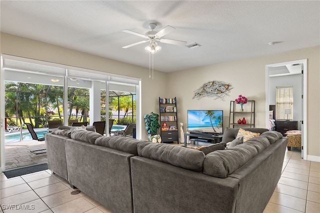 living area with light tile patterned floors, ceiling fan, visible vents, and a sunroom