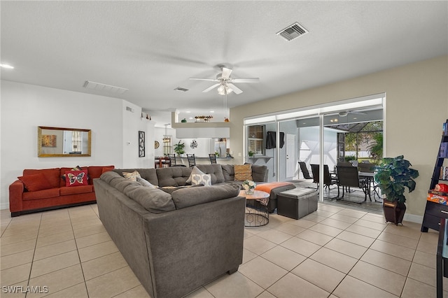 living room with light tile patterned floors, visible vents, and a ceiling fan