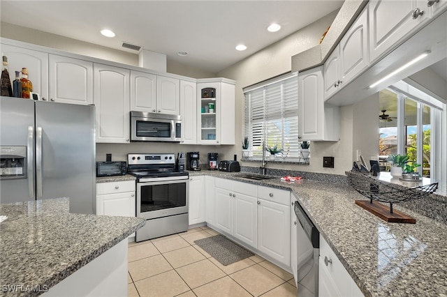 kitchen featuring dark stone countertops, sink, white cabinetry, and stainless steel appliances