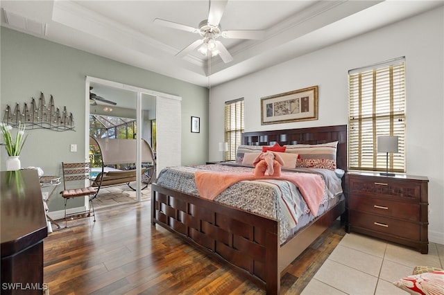 bedroom featuring a tray ceiling, ceiling fan, crown molding, and hardwood / wood-style floors