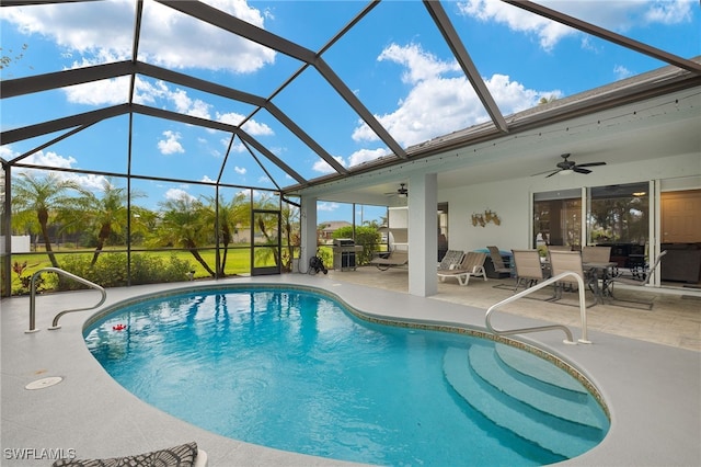 view of pool featuring glass enclosure, ceiling fan, a patio, and grilling area