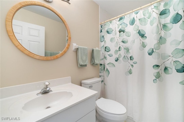 bathroom with a shower with shower curtain, vanity, and toilet