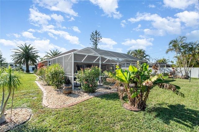 view of yard with a lanai and fence