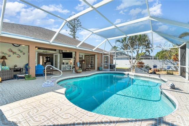 view of pool with outdoor lounge area, a patio, glass enclosure, and ceiling fan