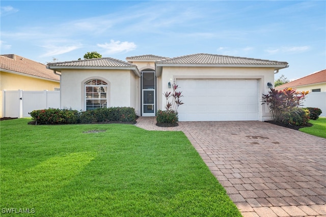 mediterranean / spanish-style house with a front yard and a garage