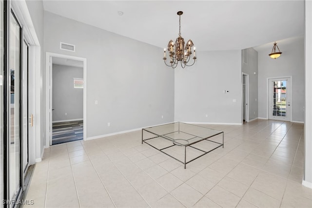 tiled spare room featuring a notable chandelier