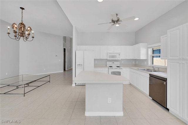 kitchen featuring white appliances, sink, pendant lighting, a center island, and white cabinetry