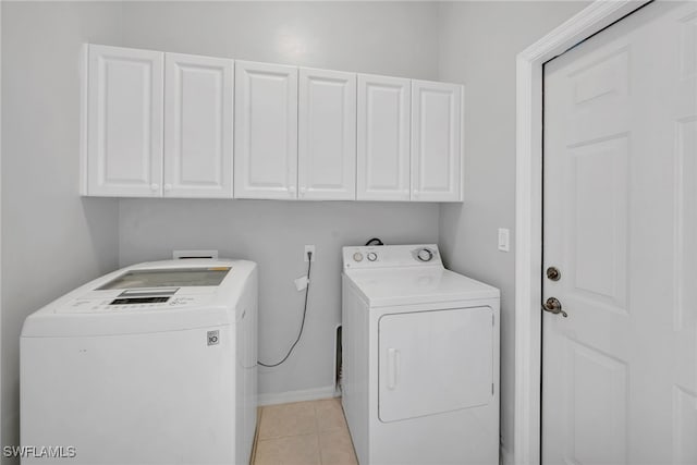 laundry area with cabinets, light tile patterned floors, and separate washer and dryer