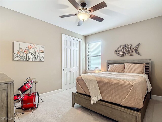 carpeted bedroom with ceiling fan and a closet