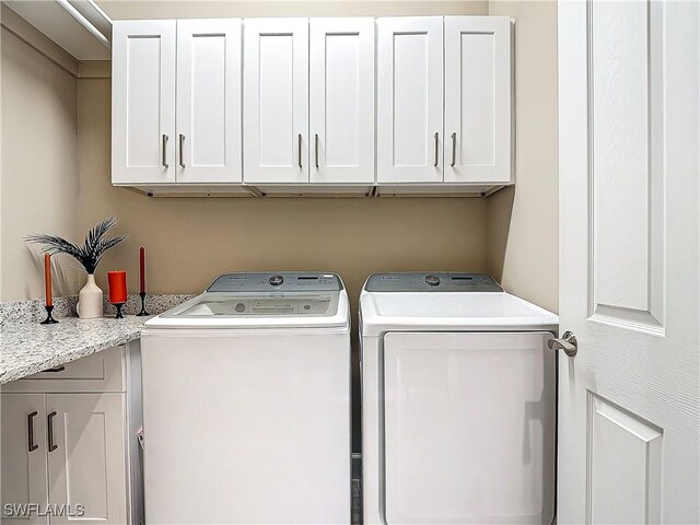 laundry room featuring cabinets and washing machine and clothes dryer