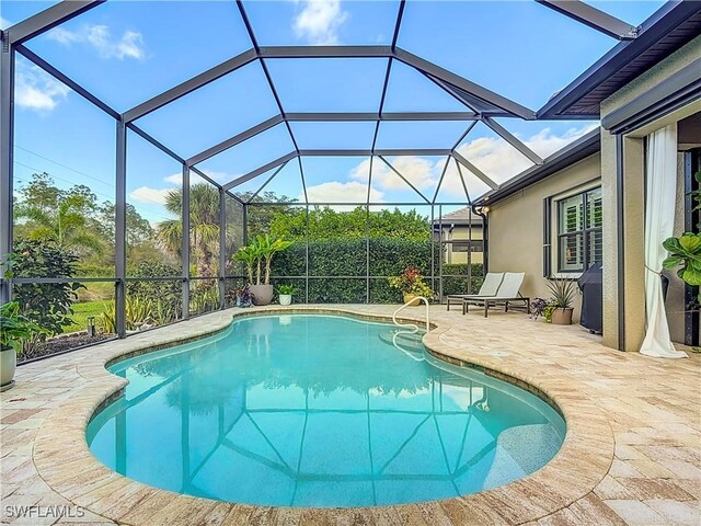 view of swimming pool featuring a lanai and a patio