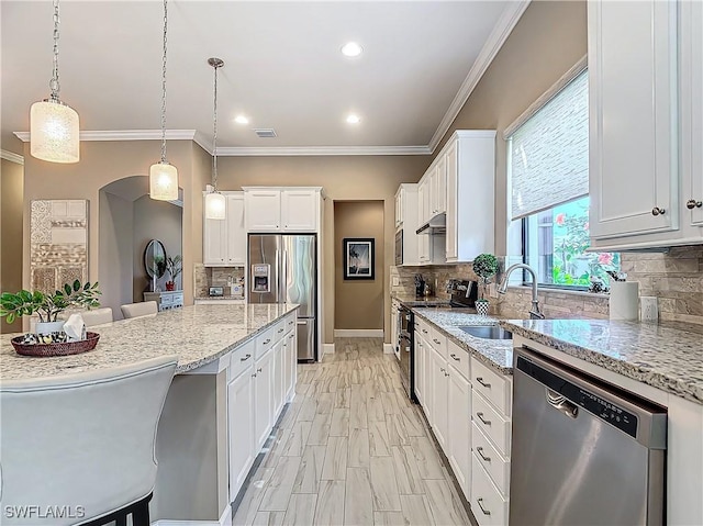 20462 Misty Woods Ct, Estero, FL 33928 - kitchen with appliances with stainless steel finishes, a sink, light stone counters, white cabinetry, and decorative backsplash