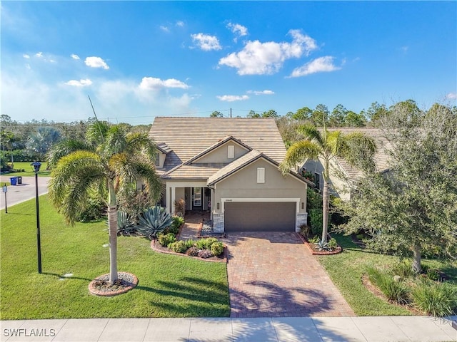 20462 Misty Woods Ct, Estero, FL 33928 - view of front of property with an attached garage, decorative driveway, stucco siding, a front lawn, and stone siding