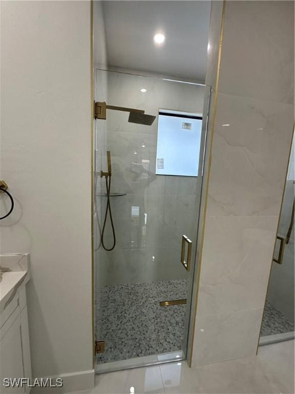 bathroom with tile patterned flooring, vanity, and walk in shower