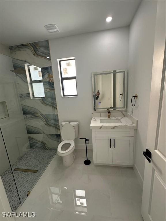 bathroom featuring tiled shower, vanity, and toilet