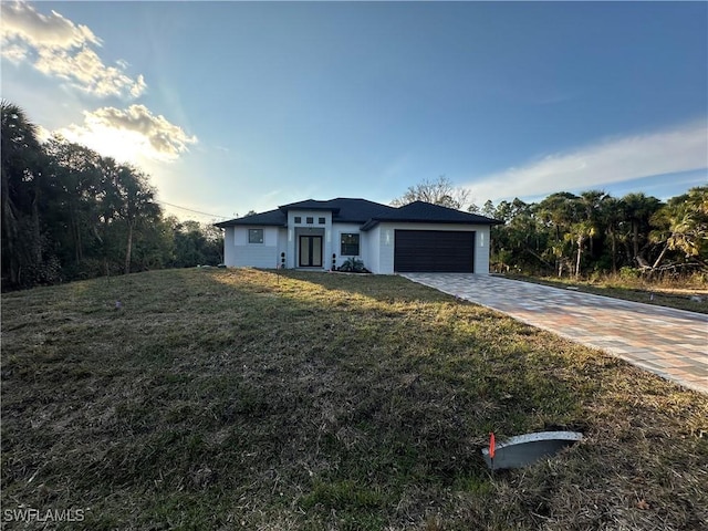 view of front of home with a front yard and a garage