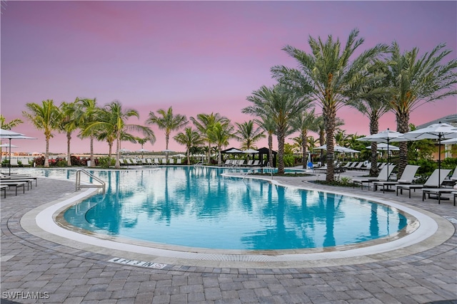 pool at dusk with a patio