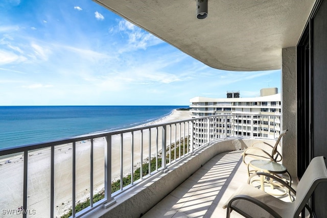 balcony featuring a water view and a view of the beach