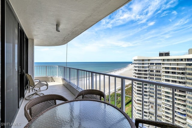 balcony with a water view and a beach view