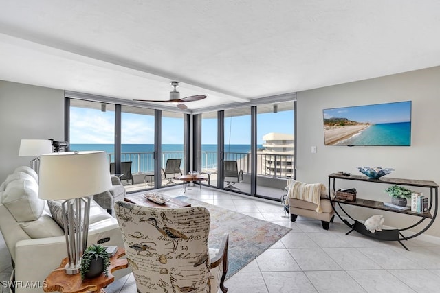 tiled living room with ceiling fan and a wall of windows