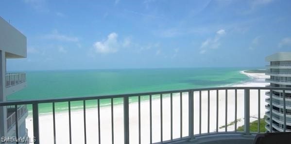 balcony with a water view and a beach view