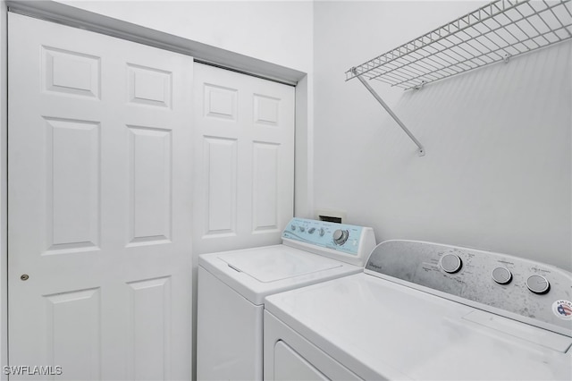 clothes washing area with washer and clothes dryer