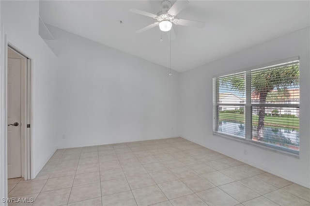 empty room featuring ceiling fan, light tile patterned floors, and lofted ceiling