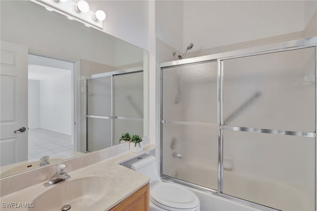 bathroom featuring toilet, shower / bath combination with glass door, tile patterned floors, and vanity