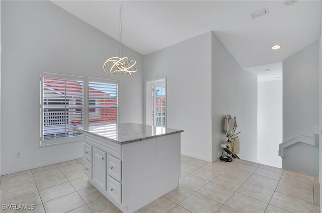 kitchen featuring white cabinets, pendant lighting, a center island, and light tile patterned flooring