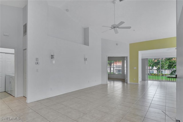 unfurnished room featuring washer / dryer, high vaulted ceiling, light tile patterned floors, and ceiling fan