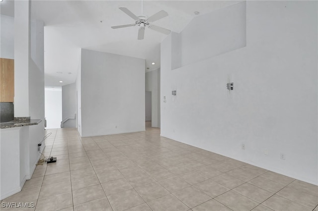 unfurnished living room with ceiling fan, high vaulted ceiling, and light tile patterned floors