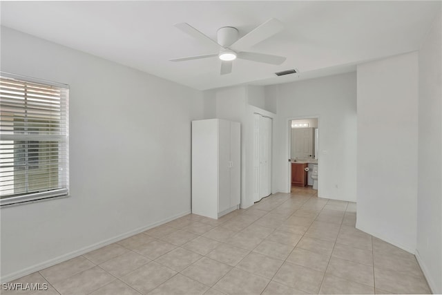 unfurnished room featuring light tile patterned floors, baseboards, visible vents, and a ceiling fan