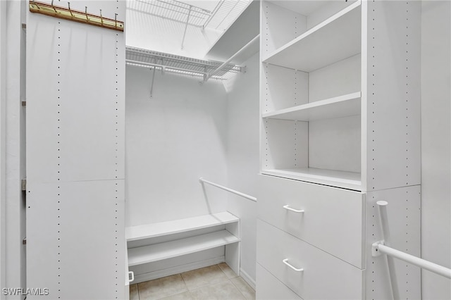 spacious closet with light tile patterned floors