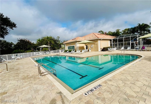 view of swimming pool featuring glass enclosure and a patio area