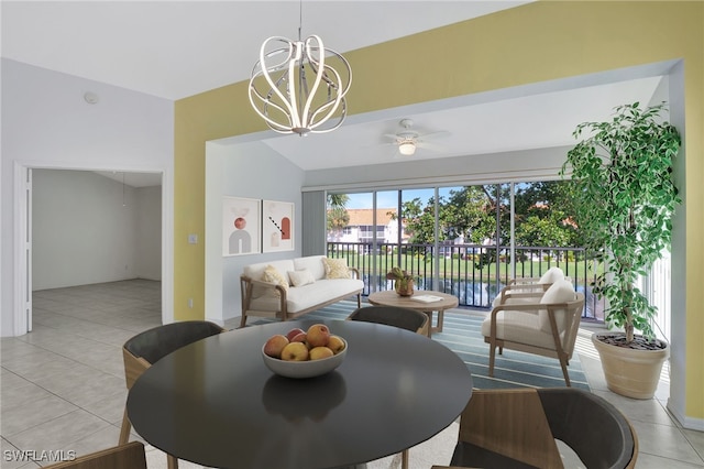 dining area with light tile patterned floors, ceiling fan with notable chandelier, and lofted ceiling