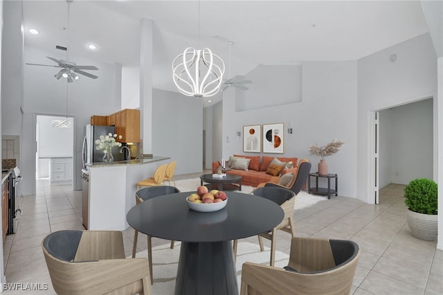 dining space featuring ceiling fan with notable chandelier, high vaulted ceiling, and light tile patterned flooring