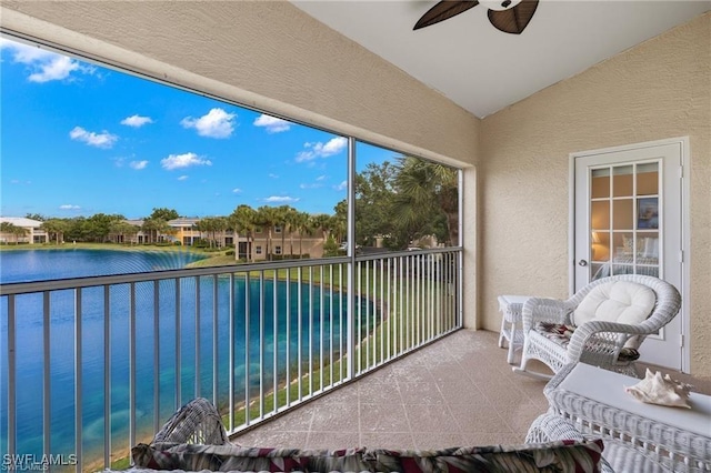 balcony with ceiling fan and a water view