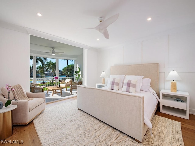 bedroom with hardwood / wood-style floors, access to outside, and ceiling fan