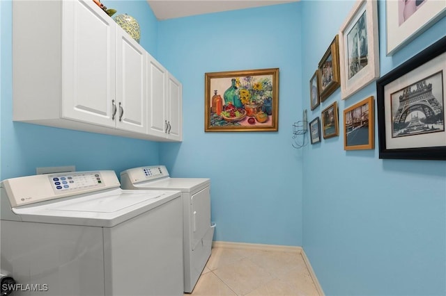 laundry room with washer and clothes dryer, cabinets, and light tile patterned floors