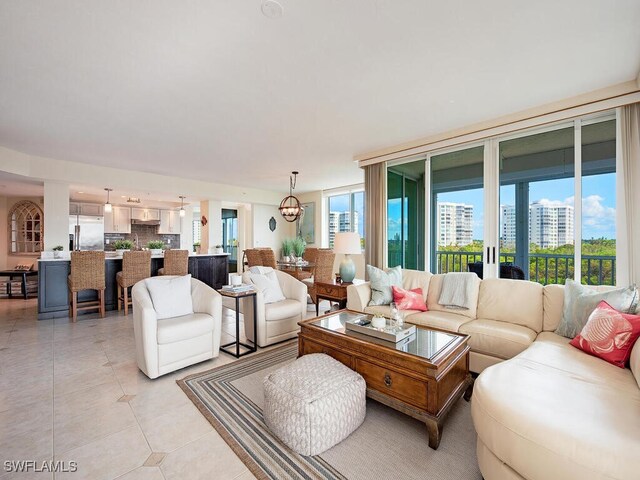 living room with light tile patterned floors and an inviting chandelier