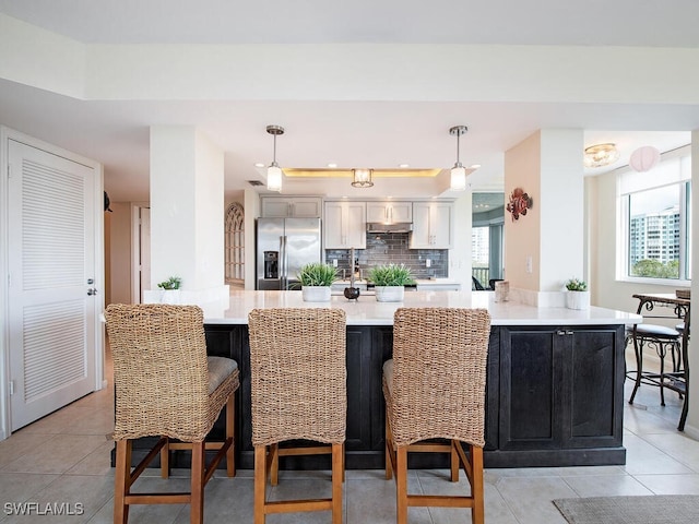 kitchen featuring white cabinets, pendant lighting, light tile patterned floors, and stainless steel refrigerator with ice dispenser