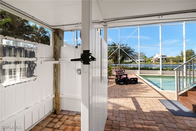 exterior space with a lanai and a water view