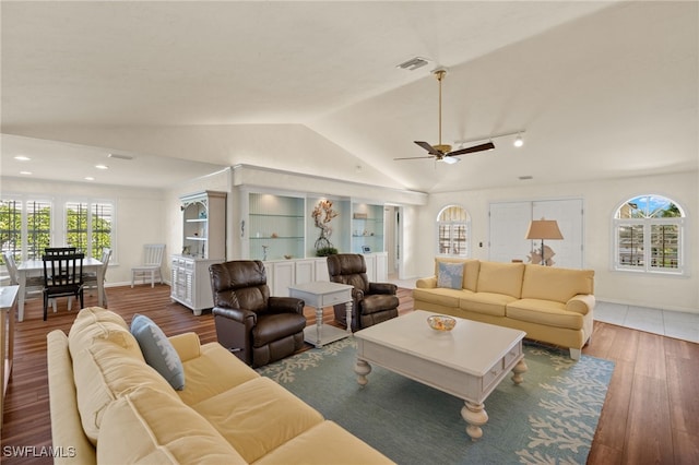 living room with ceiling fan, wood-type flooring, and lofted ceiling