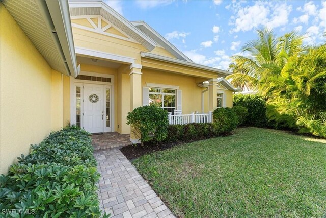 view of exterior entry with a yard