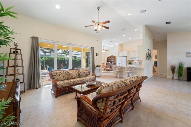 living room featuring ceiling fan and a towering ceiling