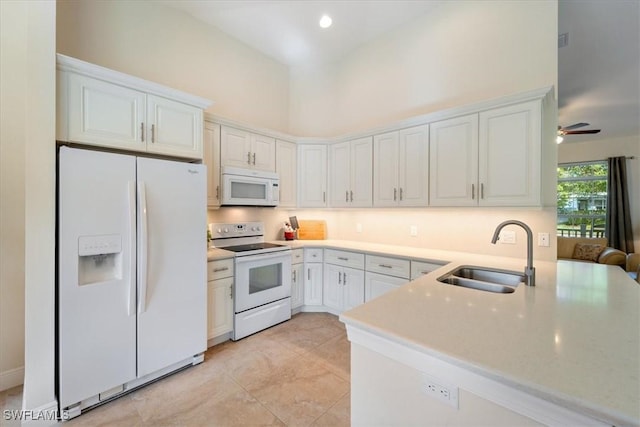 kitchen with ceiling fan, sink, a high ceiling, white appliances, and white cabinets