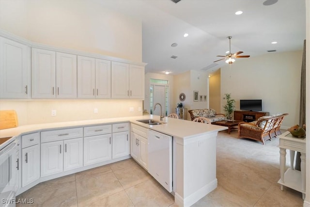 kitchen with kitchen peninsula, ceiling fan, white appliances, white cabinets, and sink